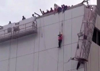 Operário ficou pendurado no alto do prédio (Foto: Reprodução)
