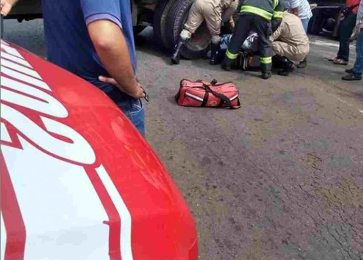 Motociclista ficou preso nas rodas traseiras do caminhão após a colisão | Foto: reprodução