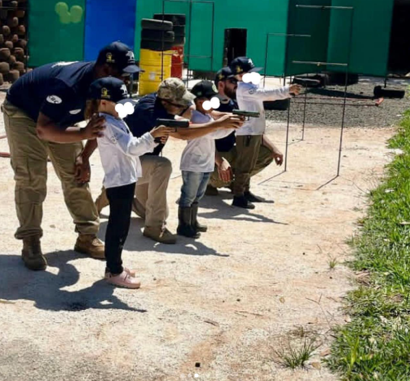 Crianças sendo lecionadas por instrutores do clube de tiro | Foto: redes sociais