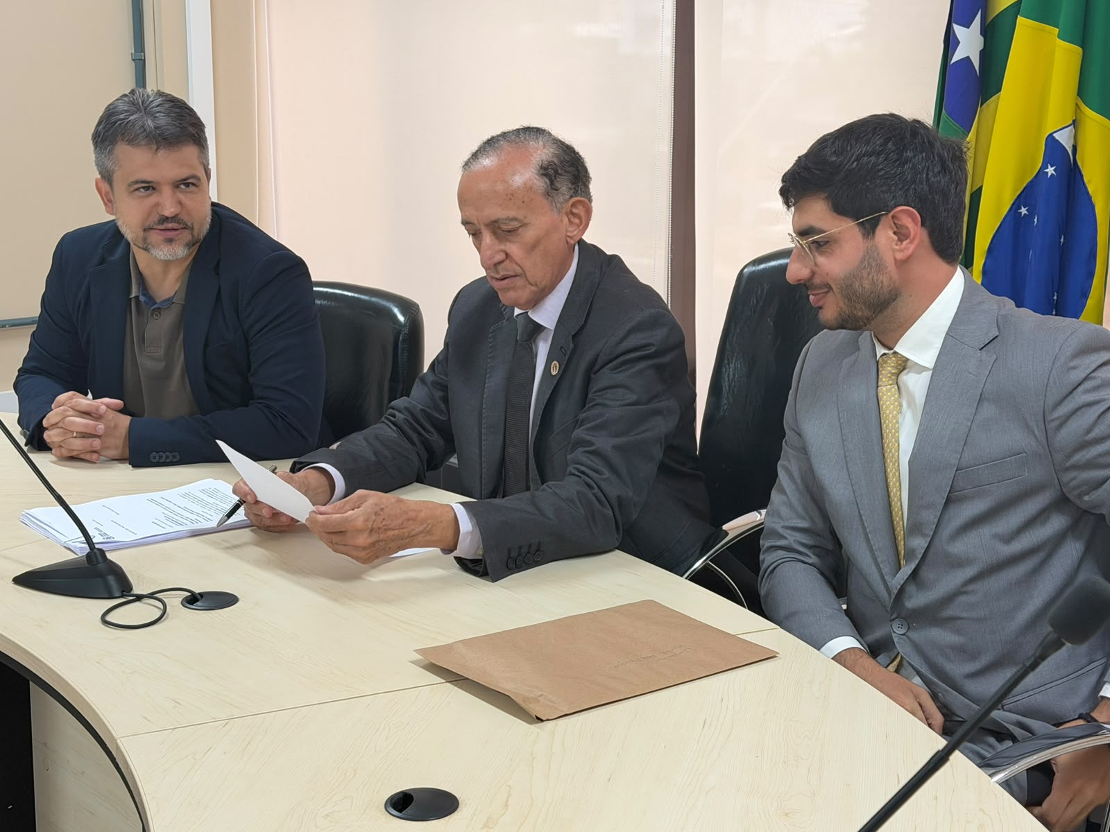 Anselmo Pereira, ao centro da foto, dá posse a Michel Magul, à direita. À esquerda, está o vereador Henrique Alves.
