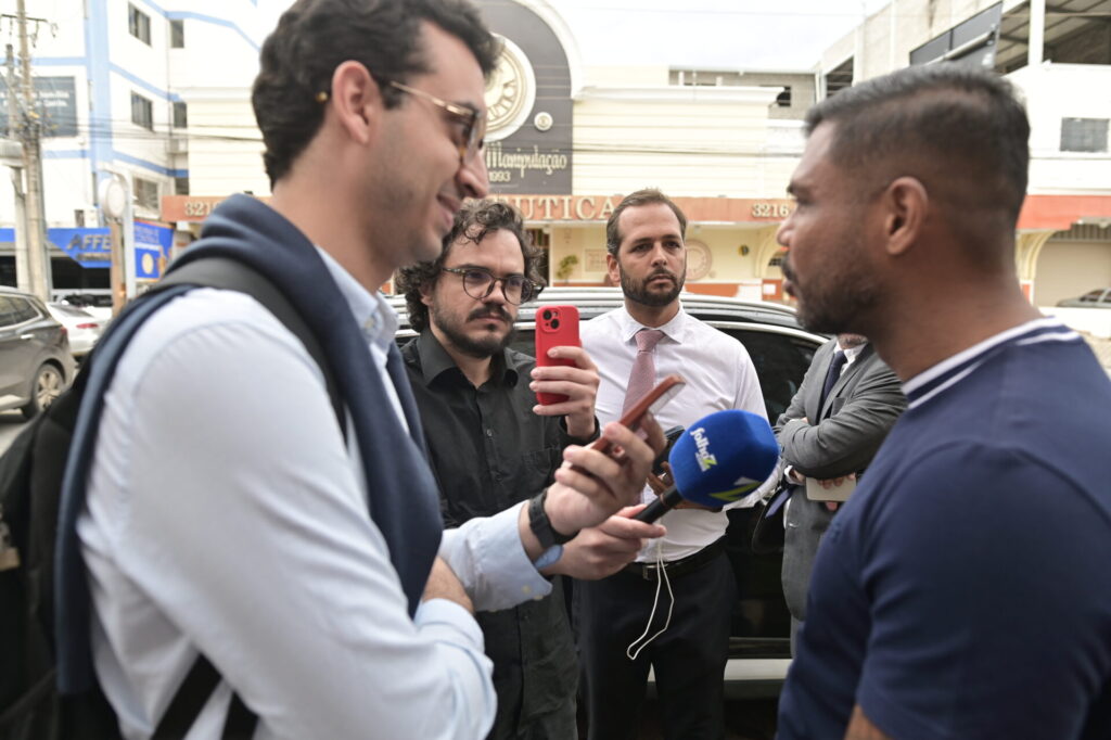Romário Policarpo concede entrevista à imprensa sob o olhar atento do jornalista Guilherme Coelho. Imagem registrada por Vinícius Oliveira da Folha Z